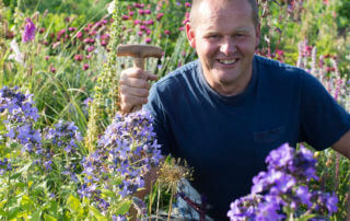 Stora planteringsveckan. John Taylor rekommenderar höstplantering. Här står han omgiven av vackra blomsterplanteringar i blått, rosa och gult.